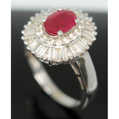 170 - A contemporary Art Deco style ruby and diamond cluster ring, the oval cut ruby set within a surround... 