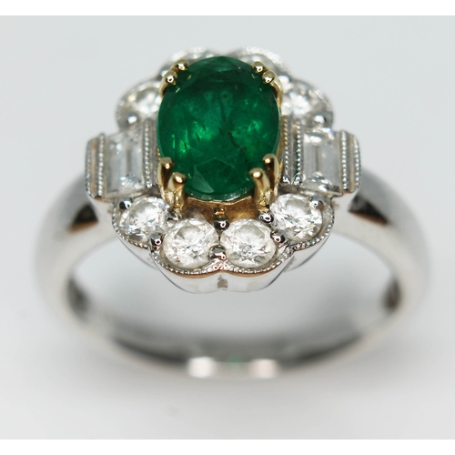 171 - A contemporary Art Deco style emerald and diamond cluster ring, the oval cut emerald set within a su... 