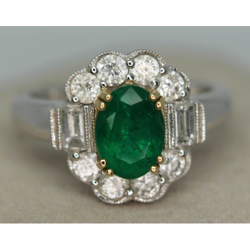 171 - A contemporary Art Deco style emerald and diamond cluster ring, the oval cut emerald set within a su... 