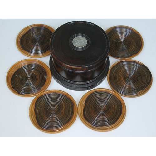 477 - A set of six lignum vitae coasters with cylindrical box, the lid inset with a George IV coin.