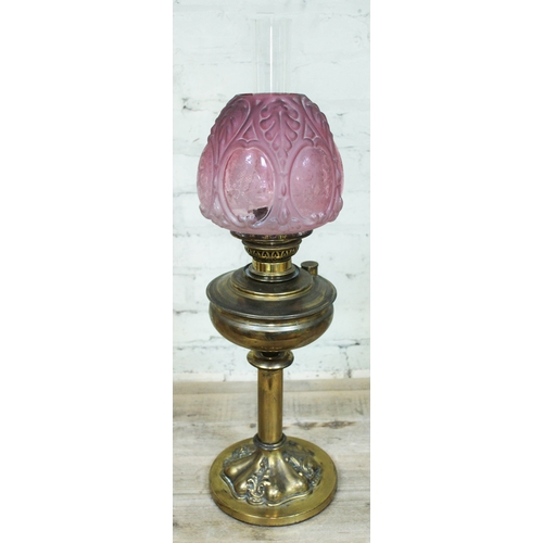 90 - A Victorian brass oil lamp with etched cranberry glass shade, height 69cm.