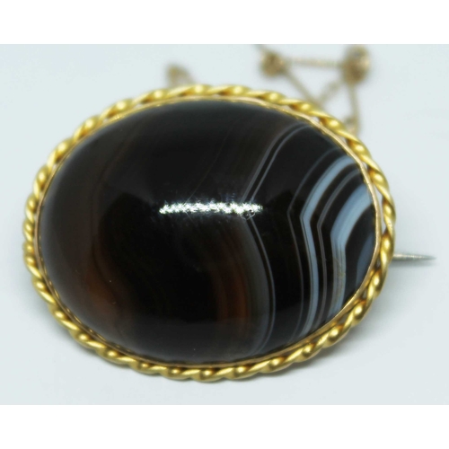 116 - A 9ct gold brooch set with a large agate cabochon, marked '9ct', gross wt. 12.1g, length 31mm.