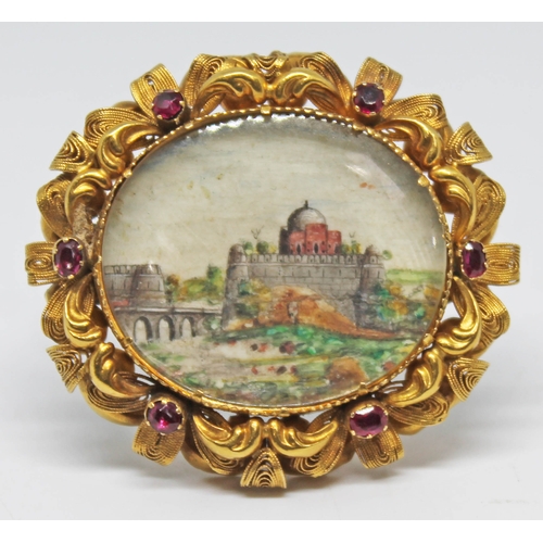 210 - A Victorian yellow metal brooch set with rubies and an Indian oval miniature on ivory, length 44cm.