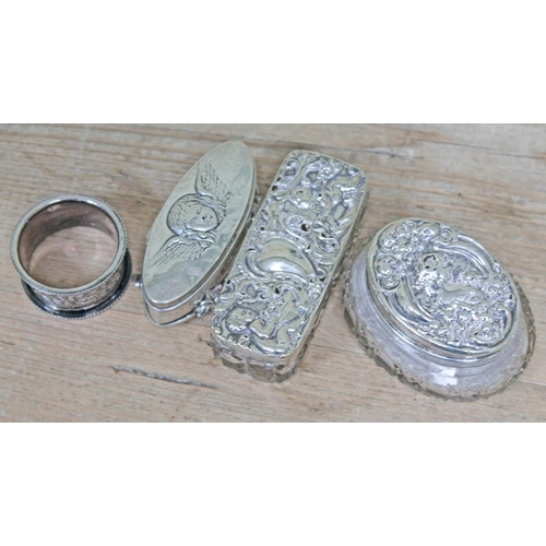 216 - Hallmarked silver comprising a serviette ring, an oval box embossed with a cherub and two silver top... 