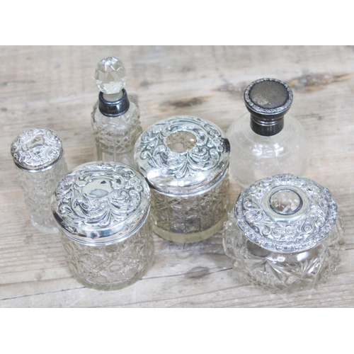 217 - A group of six hallmarked silver topped/mounted jars and scent bottles.