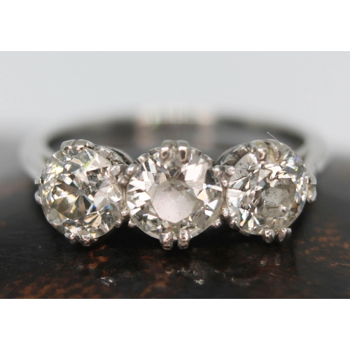 219 - An early 20th century three stone diamond ring, the three round cut stones weighing approx. 0.59, 0.... 