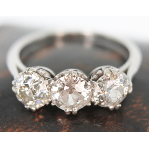 219 - An early 20th century three stone diamond ring, the three round cut stones weighing approx. 0.59, 0.... 