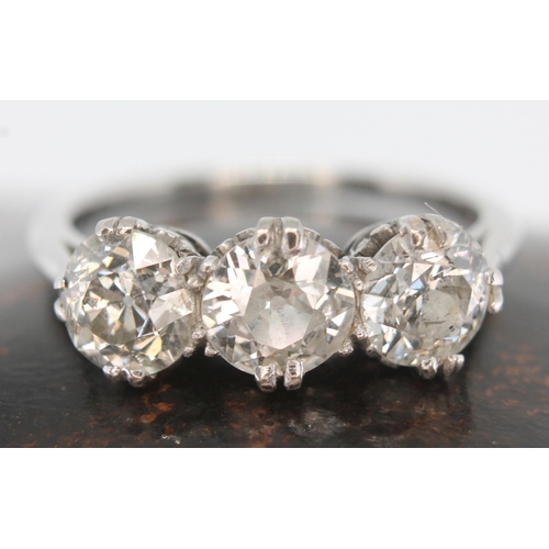 219 - An early 20th century three stone diamond ring, the three round cut stones weighing approx. 0.59, 0.... 