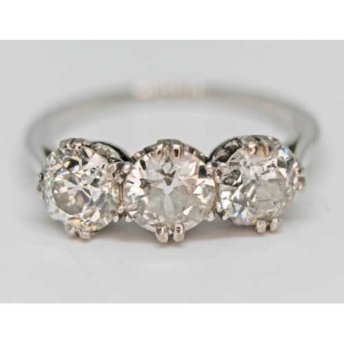 219 - An early 20th century three stone diamond ring, the three round cut stones weighing approx. 0.59, 0.... 