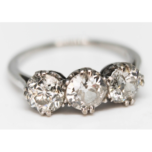 219 - An early 20th century three stone diamond ring, the three round cut stones weighing approx. 0.59, 0.... 