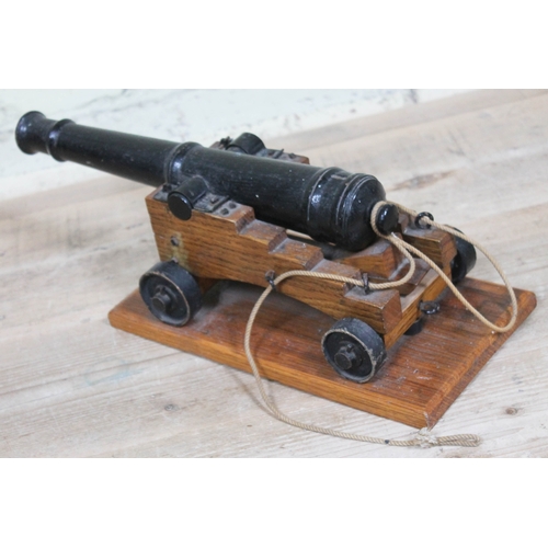 90 - A cast iron model signal cannon on wooden base, barrel length 37cm.