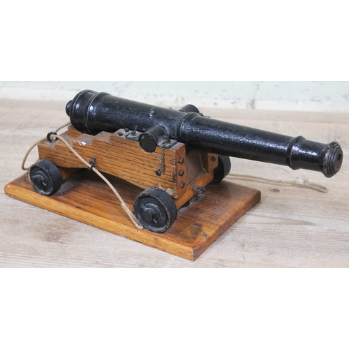 90 - A cast iron model signal cannon on wooden base, barrel length 37cm.