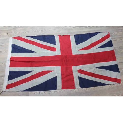 519 - A group of four vintage flags comprising three Union Jacks and one United States, 158cm x 81cm, 269c... 