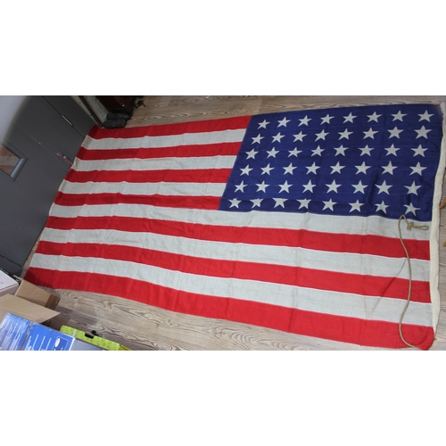 519 - A group of four vintage flags comprising three Union Jacks and one United States, 158cm x 81cm, 269c... 