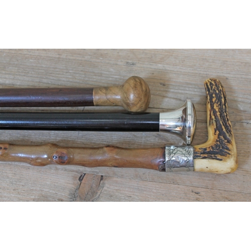 527 - A group of three walking sticks, one with hallmarked silver top, one with knobbly shaft, white metal... 