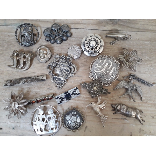 148 - A group of 21 silver and white metal brooches.