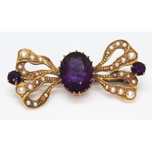 108 - A 15ct gold brooch of bow form and set with amethyst coloured stones and split pearls, marked '15ct'... 