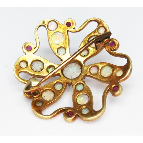 109 - A yellow metal brooch of flower form and set with opal cabochons and ruby coloured stones, diam. 27m... 