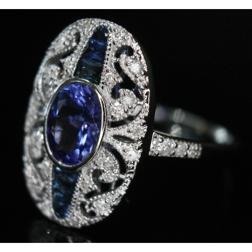 171 - An Art Deco style 18ct white gold tanzanite, sapphire and diamond ring, the central oval cut and bez... 