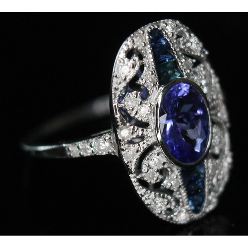 171 - An Art Deco style 18ct white gold tanzanite, sapphire and diamond ring, the central oval cut and bez... 