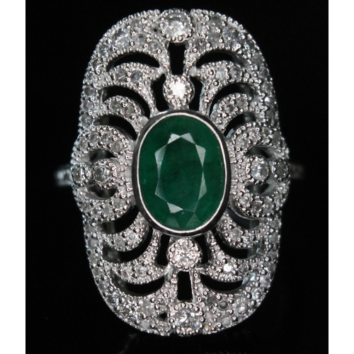 172 - An 18ct white gold emerald and diamond ring, the central oval cut emerald approx. 1.08ct, surround b... 