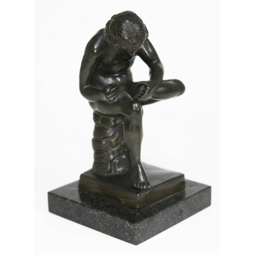 429 - An early 20th century spelter figure with bronze finish depicting a man tending to his foot on marbl... 