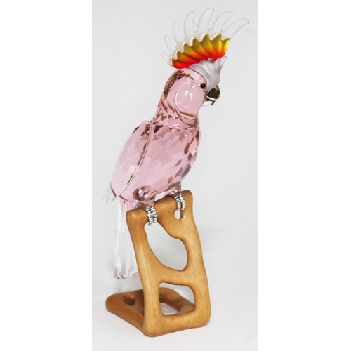 438 - A Swarovski Paradise Birds cockatoo on naturalistically formed wooden base, height 24cm.