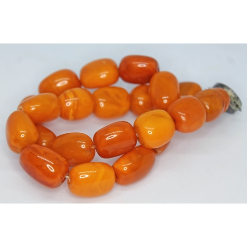 98 - A single strand of butterscotch amber beads, length 40.5cm, beads ranging from 17mm - 22mm, white me... 