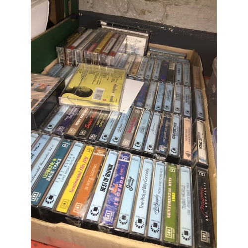 174 - A box of 74 cassette tapes, most factory sealed