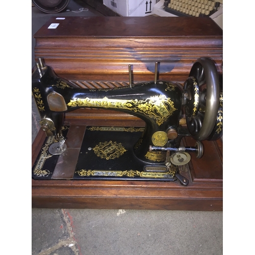 116 - An Edwardian walnut cased hand crank sewing machine with bobbins.