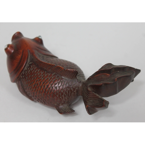 64 - A Japanese carved wooden carp with glass eyes, length 15cm.