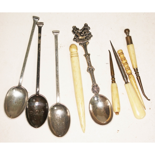 92 - Three hallmarked silver teaspoons, another souvenir spoon, and four bone accoutrements.