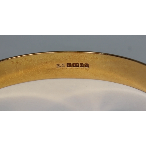 102 - A hallmarked 18ct gold bright cut engraved and adjustable bangle, wt. 30.93g.