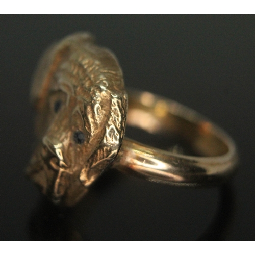 139 - A novelty ring formed as a dog's head and set with blue stones for eyes, marked '9ct', gross wt. 9.2... 