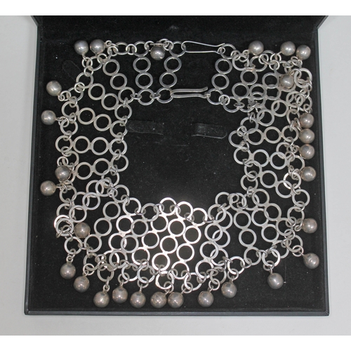 275 - A contemporary silver collar necklace formed as linked rings with drop spheres, length approx. 41cm,... 