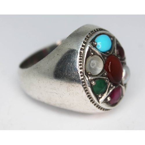 291 - A contemporary multi gemstone ring set with a central amber cabochon and surround by moonstone, turq... 