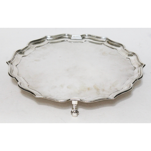 305 - A silver salver with pie crust edge on three raised scrolled feet, Adie Bros. Ltd, Birmingham 1931, ... 