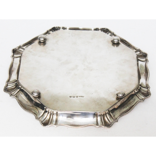 306 - A hallmarked octagonal shaped salver raised on four bun feet, Joseph Gloster Ltd, Birmingham 1923, d... 