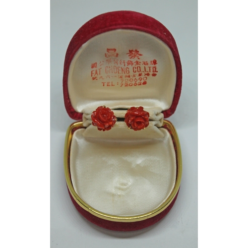 368 - A pair of carved coral ear studs, marked '18K', length 2mm, gross wt. 4.91g, with box stamped 'Fat C... 