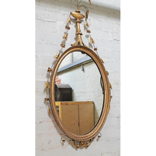 86 - A 19th century gilded oval mirror, length 110cm.
