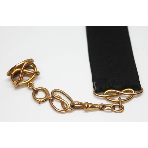 97 - A yellow metal fob on chain and clasp marked '9ct', suspended on black ribbon, wt. excluding ribbon ... 