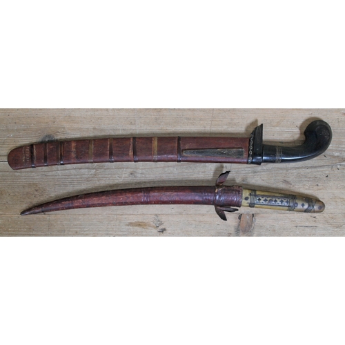 398 - A North African short sword with horn handle and leather scabbard length 53cm and an eastern short s... 