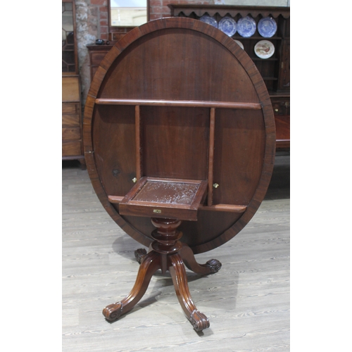 88C - A 19th century mahogany loo table of oval form with turned pedestal base with four legs having scrol... 