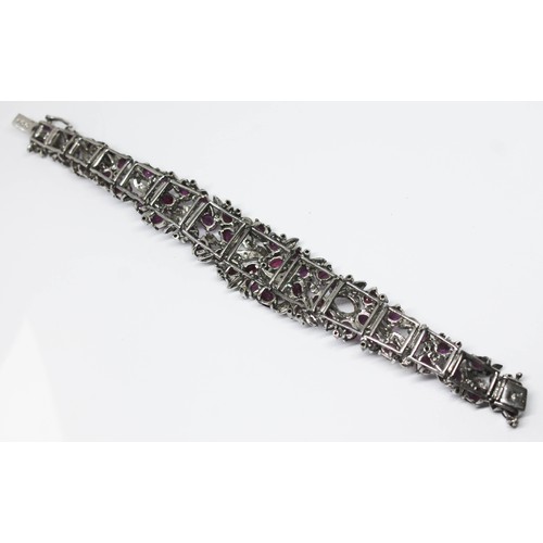 100A - A continental white metal ruby and diamond cocktail bracelet, length 16.5cm, gross wt. 47.29g.