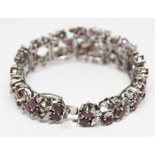 100A - A continental white metal ruby and diamond cocktail bracelet, length 16.5cm, gross wt. 47.29g.