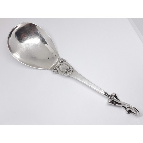 321 - A Georg Jensen Sterling silver spoon number 49, scroll finial and hammered bowl, length 18.5cm.