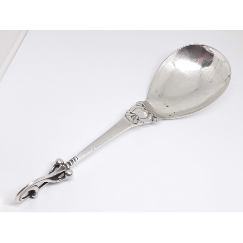 321 - A Georg Jensen Sterling silver spoon number 49, scroll finial and hammered bowl, length 18.5cm.