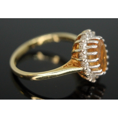 102 - A citrine and diamond cluster ring, the central stone measuring approx. 8mm x 5mm x 2mm, surrouned b... 