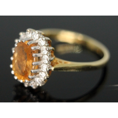 102 - A citrine and diamond cluster ring, the central stone measuring approx. 8mm x 5mm x 2mm, surrouned b... 