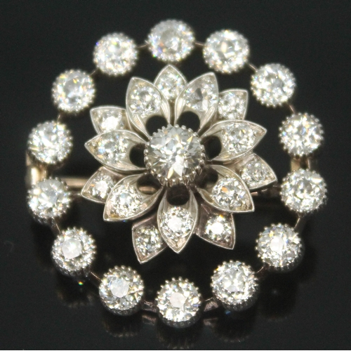 167 - An Art Deco diamond cluster brooch, the old cut central stone weighing approx. 0.25 carats, surround... 